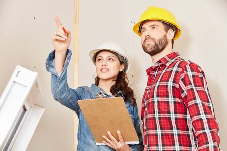 Architect with checklist planning and cooperating with craftsman