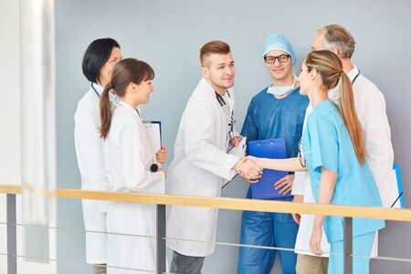 Young doctor in training shake hands with team of doctorsの写真素材