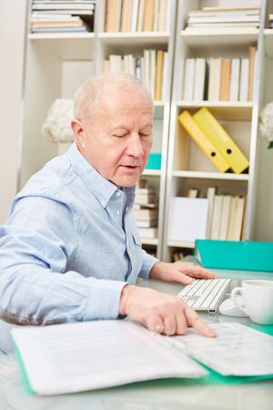 Senior businessman controls his documentation with competenceの写真素材
