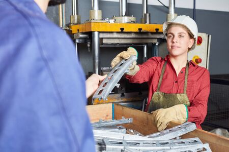 Woman as blue collar worker apprentice working in cooperation