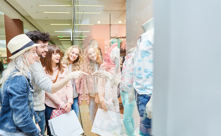 Group of teenagers is having fun shopping in front of a shop windowの写真素材