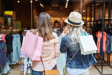 Two women shopping as customers in front of a retail boutiqueの写真素材