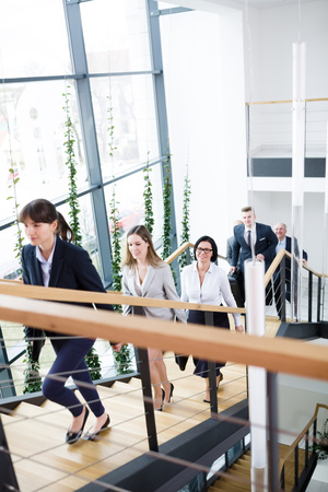 High angle view of business executives moving upstairs in modern officeの写真素材