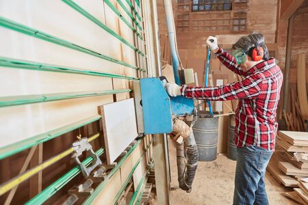 Carpenter at carpentry shop working with plate saw