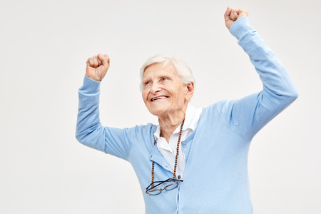 Senior celebrates with clenched fists as a sign of zest for life and vitalityの写真素材
