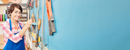 Panorama of young woman next to tools at carpenter's workshop の写真素材