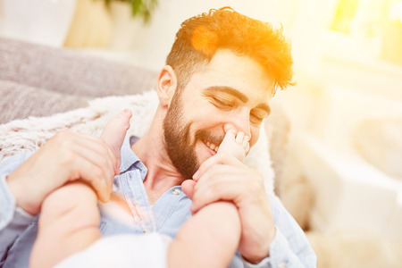 Father holds the feet of his little babyの写真素材