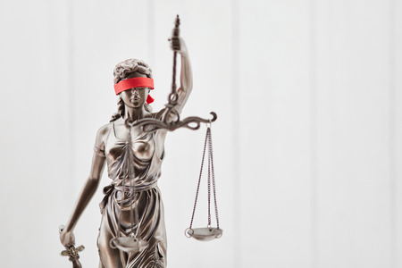 Blind Justitia figure with blindfold as law concept against wood backgroundの写真素材