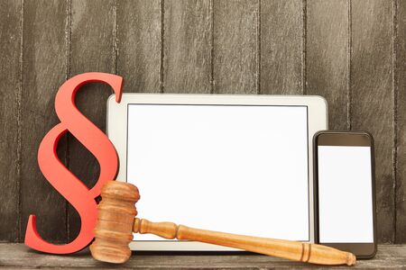 Tablet computer and smartphone in addition to IT law symbols such as paragraph and gavelの写真素材