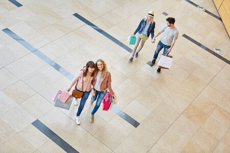 Friends go for a shopping spree in the shopping mallの写真素材