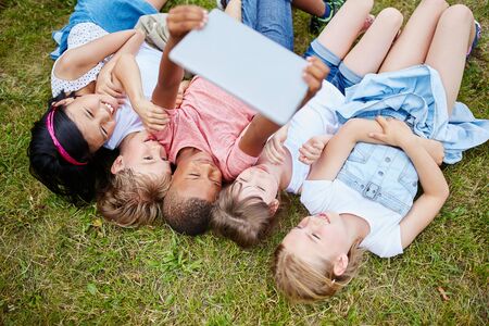 Children taking group photo selfie with tablet computerの写真素材