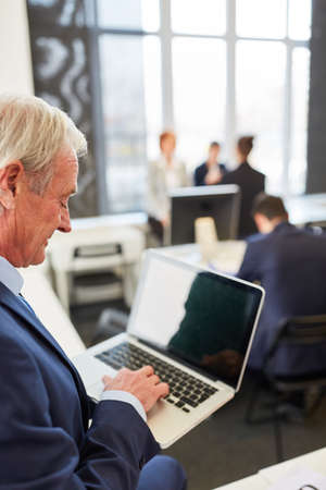 Senior business man working online with laptop computerの写真素材
