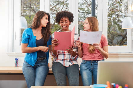 Three young women as students or apprentices are learning together in the officeの写真素材