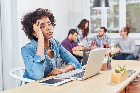 Young business start-up woman on laptop is thinking about difficult decisionの写真素材
