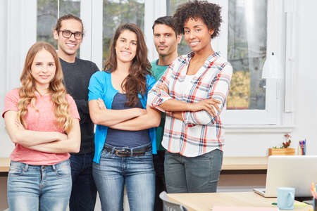 Students as young startups of a business start-up smile confidently in the office