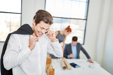 Young businessman calls with joy at start-up meetingの写真素材