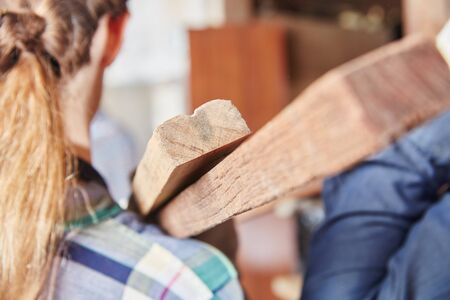 Woman carrying wood during carpentry apprenticeship の写真素材