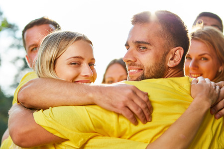Young people hug happily at the teambuilding workshop in natureの写真素材