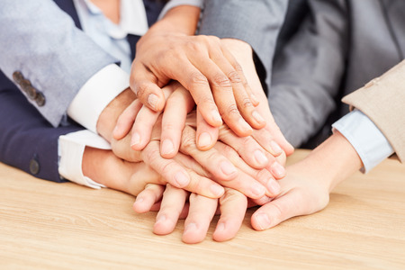 Business start-up team stacks hands as a sign of trust and partnership