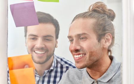 Two students brainstorming with notes in creative business workshopの写真素材