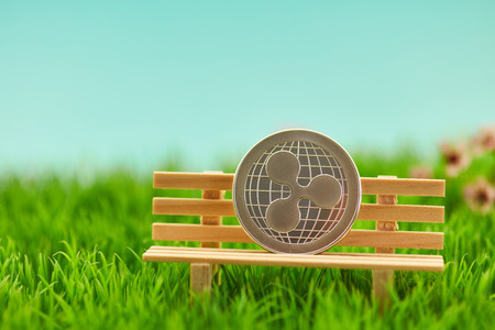 Ripple coin on bench in the garden as a pension conceptの写真素材