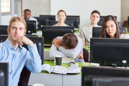 Tired or lazy tudent sleeps in uni computer course lessonの写真素材