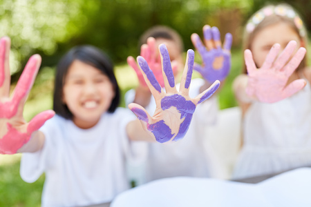Children playfully paint with finger paints on a children's birthday partyの写真素材