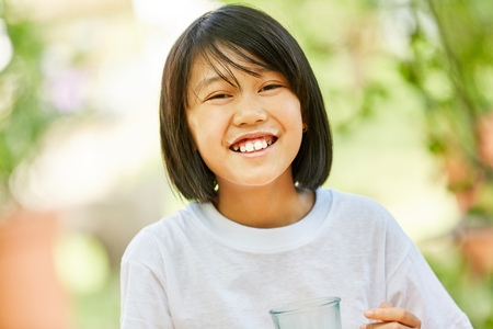 Asian girl is drinking a glass with healthy milk for breakfastの写真素材