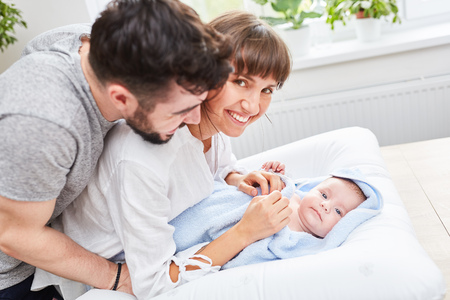 Happy parents are happy about their baby wrapped in a towel