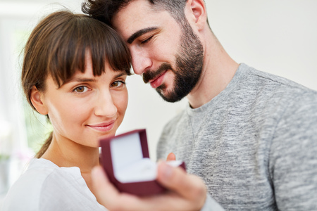Young man with wedding rings in a box makes a declaration of love to woman