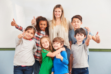Happy students of a multicultural elementary school keep their fingers crossedの写真素材