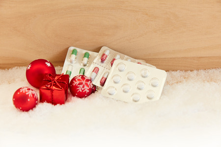 Medication for Christmas as a gift next to Christmas tree ballsの写真素材