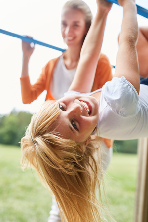 Sporty girl is doing gymnastics on a climbing poleの写真素材
