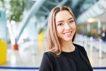Young woman as a traveler and smiling business woman in airport terminalの写真素材