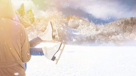 Man carry woman with ice-skates in winter in the snowの写真素材