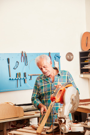 Senior carpenter works on new instrument's fingerboardの写真素材