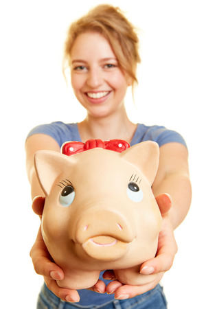 Young woman holds money box or piggy bank in her hands as a money saving conceptの写真素材