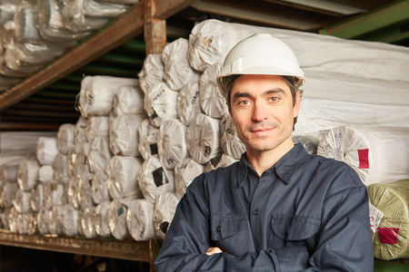 Man with safety helmet as warehouse worker or warehouse specialist in the carpet warehouseの写真素材