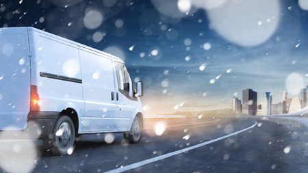 Delivery van driving in snow on a road to a city (3D Rendering)の写真素材