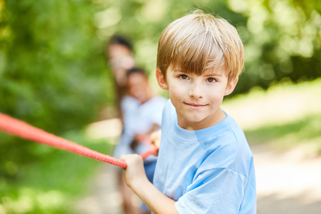 Determined boy at the rope pulling competition in summer campの写真素材