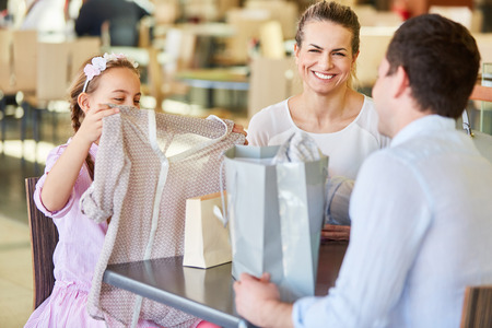 Girl is amazed at fashion gift in mall while shoppingの写真素材