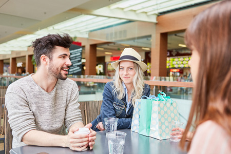Group of friends talking to each other in a shopping break at the mall