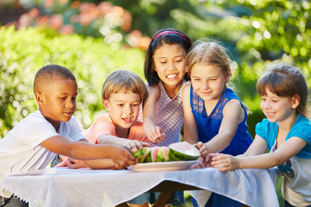 Many interracial kids eating watermelon in summerの写真素材