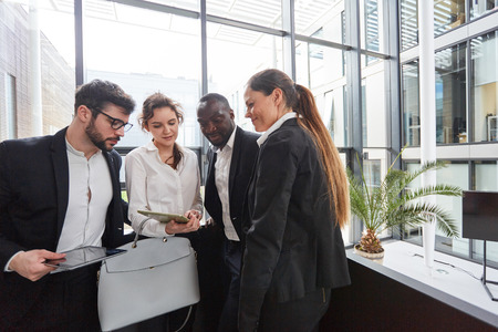 Group of Business People with Tablet PC Brainstorming in Modern Office