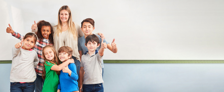 Multicultural children in elementary school class keep their fingers crossedの写真素材