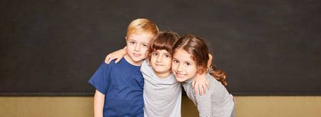 Group of kids is standing together in front of a blackboard in elementary school