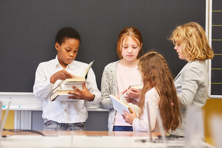 Group of children together read books in a primary school study groupの写真素材