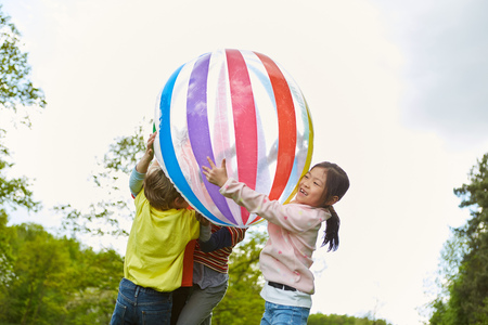 Kindergarten Children have fun playing ball in the park in natureの写真素材