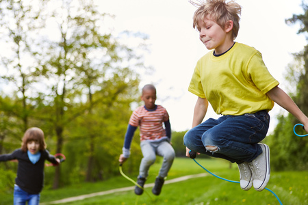 Boy in the park together with friends in competition in rope skipping in summerの写真素材