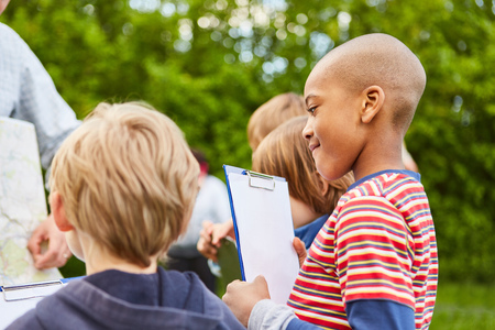Children together make a field game or a treasure hunt in kindergartenの写真素材
